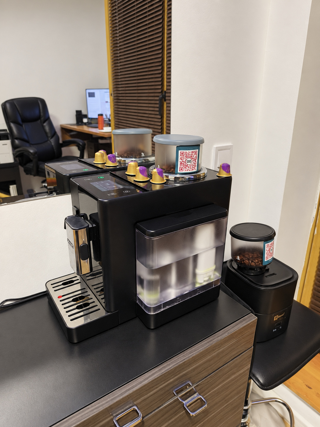 Coffee bean containers with TidyBox QR labels beside a coffee machine in a home office